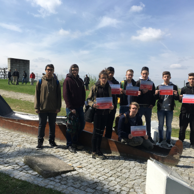 Jugendliche halten Schilder mit den Botschaften "Solidarität wirkt", "Zivilcourage wirkt" und "Niemals wieder" in der KZ-Gedenkstätte Mauthausen