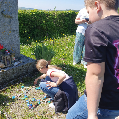 Eine Schülerin legt einen bemalten Stein vor dem Denkmal nieder © Fritz Käferböck-Stelzer