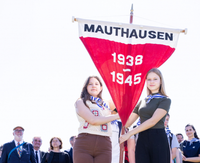 Jugendliche halten den Wimpel mit der Aufschrift "Mauthausen 1938 - 1945" bei der Internationalen Gedenk- und Befreiungsfeier in Mauthausen 2022 © MKÖ/Sebastian Philipp